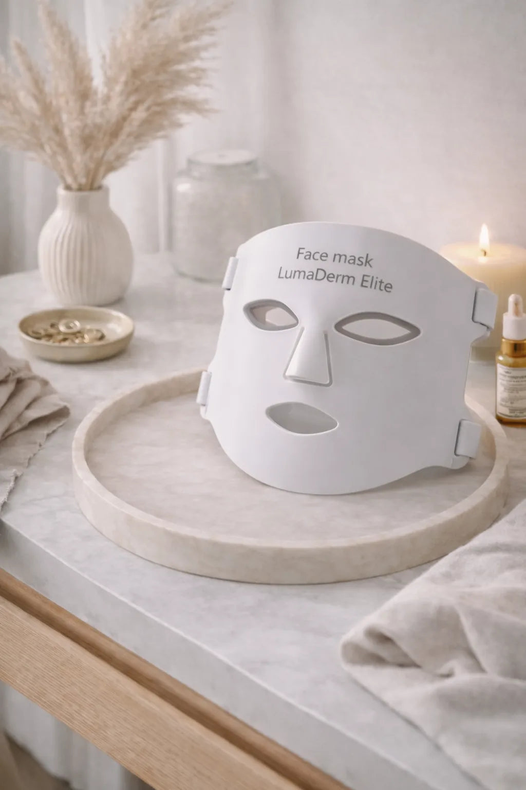 White face mask labeled 'LumaDerm Elite' on a wooden tray with a neutral background