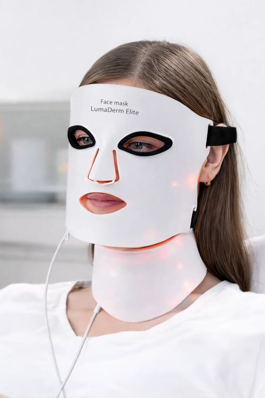 Woman wearing a white LED face and neck mask with visible branding.